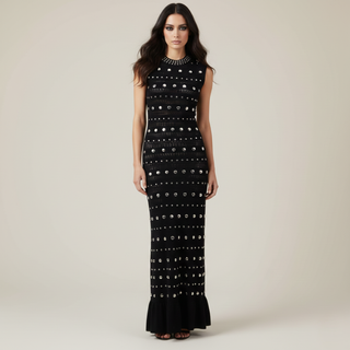 Woman wearing a black dress with white patterns on a beige background