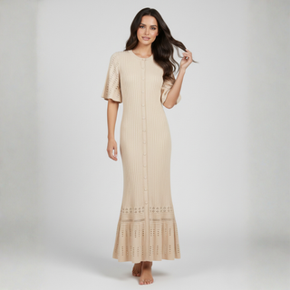 Woman wearing a beige dress with lace details on a white background