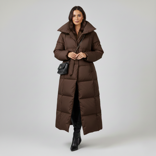 Woman wearing a long brown puffer coat on a light gray background