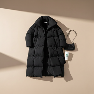 Black puffer coat on a beige background with a Starbucks cup and bag.