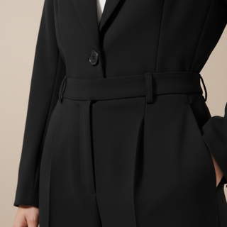 Black suit jacket with a belt on a beige background