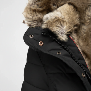 Close-up of a black coat with fur-lined hood on a light gray background