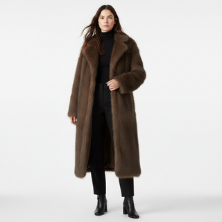 Woman wearing a long brown coat on a white background