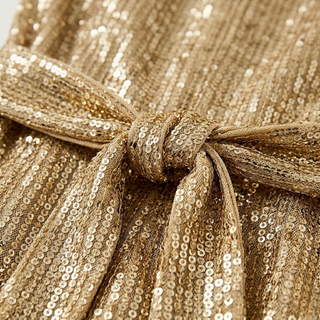 Close-up of a gold sequin fabric with a knot