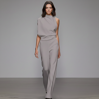 Model wearing a gray outfit on a runway with a plain background