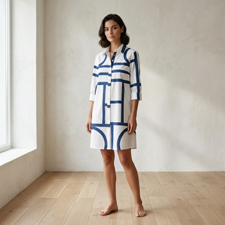 Symmetrical ghost mannequin view of a white and navy blue patterned shirt dress highlighting the button-down front and structured hem.