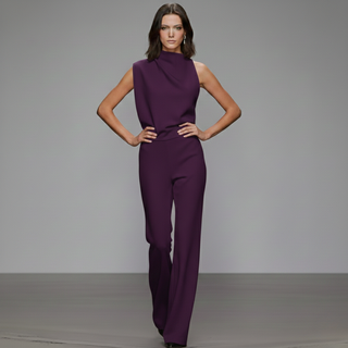 Woman wearing a purple jumpsuit on a gray background