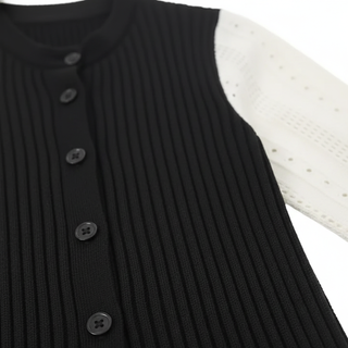 Black ribbed sweater with button details on a white background