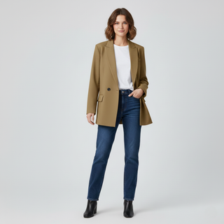 Woman wearing a brown blazer, white shirt, blue jeans, and black shoes on a light gray background