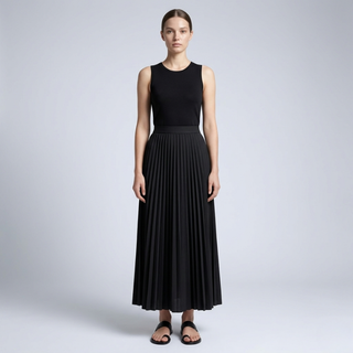 Woman wearing a black sleeveless top and pleated skirt on a light gray background