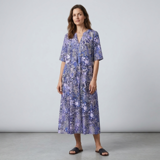 Woman wearing a blue floral dress against a plain background