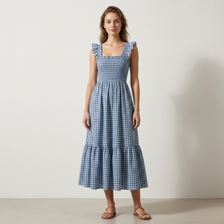 Woman wearing a blue checkered dress against a plain background