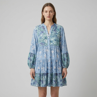 Woman wearing a blue floral dress on a gray background