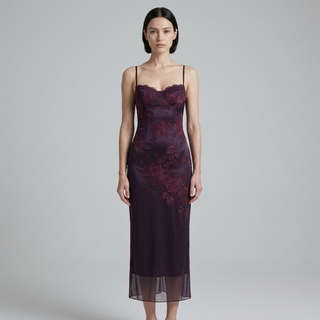 Woman wearing a dark purple lace dress on a gray background