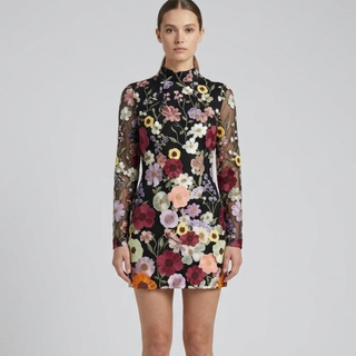 Woman wearing a floral dress with a plain background