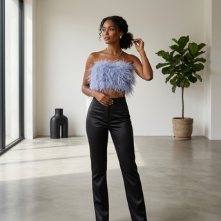 Woman wearing a strapless outfit with feather details in a modern room.