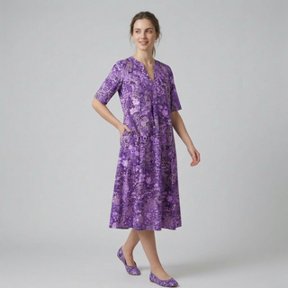 Woman wearing a purple floral dress on a gray background