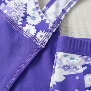 Extreme close-up showing the high-quality stitching and floral pattern detail on the purple tankini set.