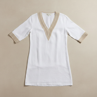White tunic with beige trim on a beige background